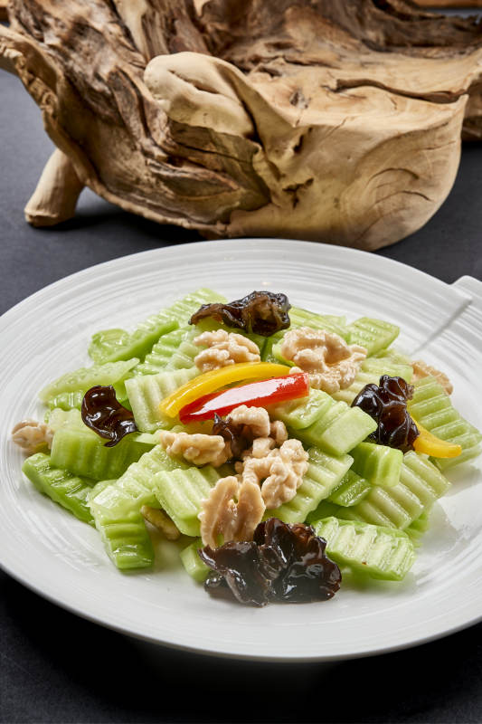 圓瓷盤裝的乳瓜桃仁彩椒炒木耳