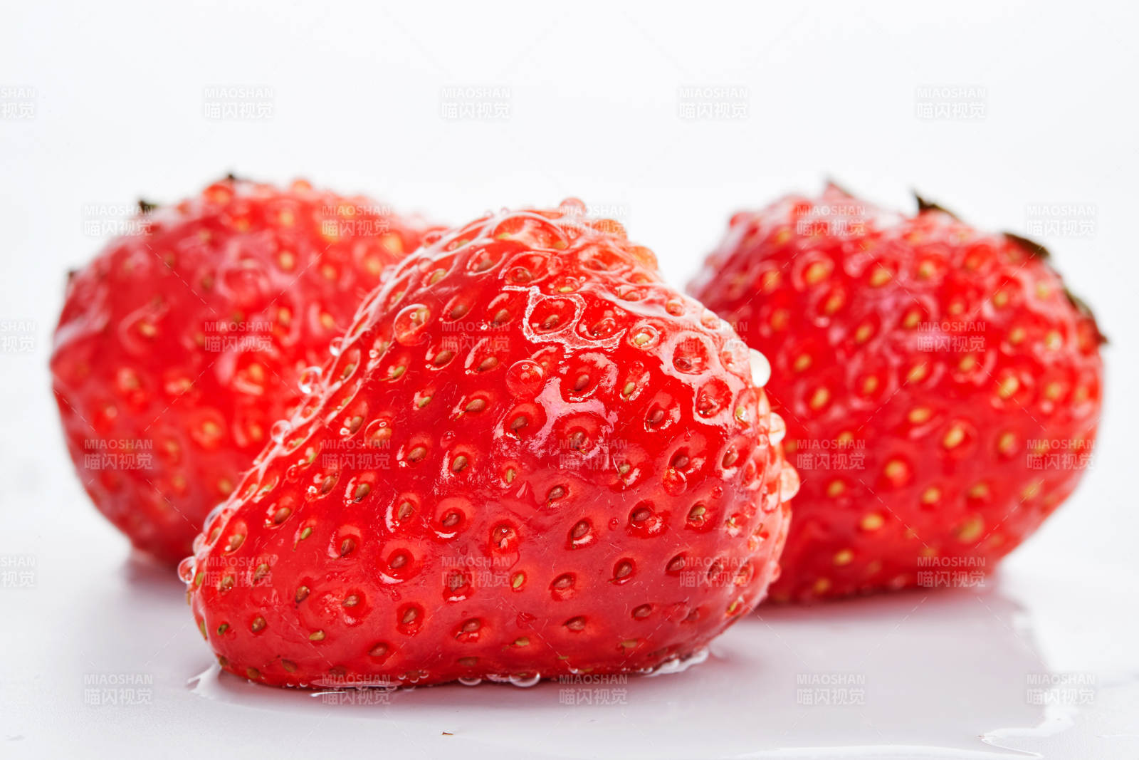 白色背景上摆放的水嫩新鲜草莓