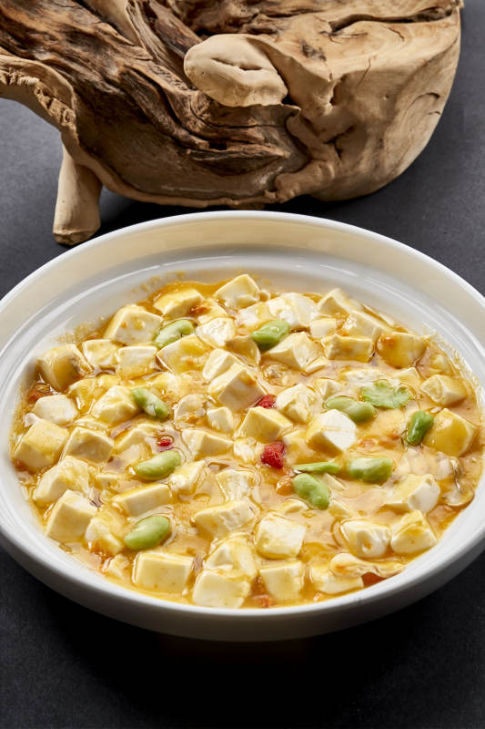 白色圆瓷盘装的蟹黄芸豆焗豆腐