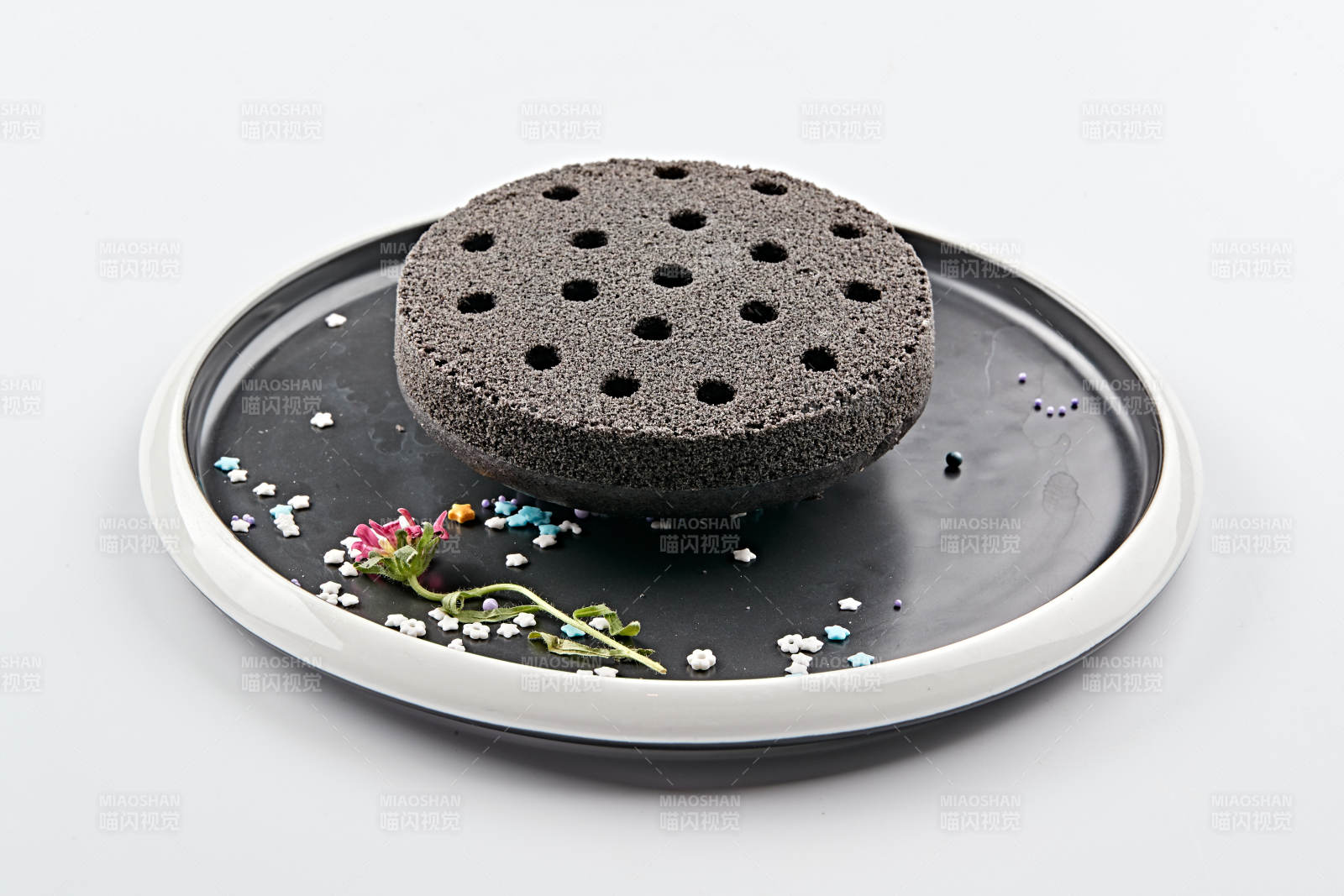 精美餐具装的竹炭粉黑米面蜂窝米糕