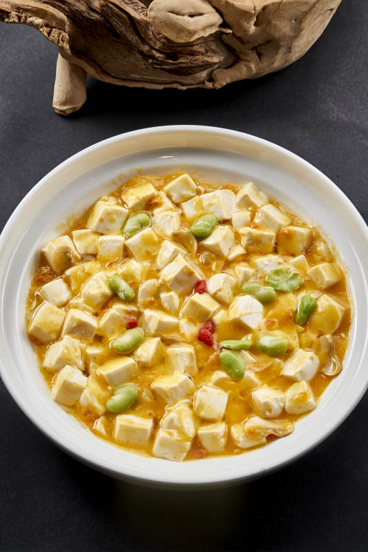白色圆瓷盘装的蟹黄芸豆焗豆腐