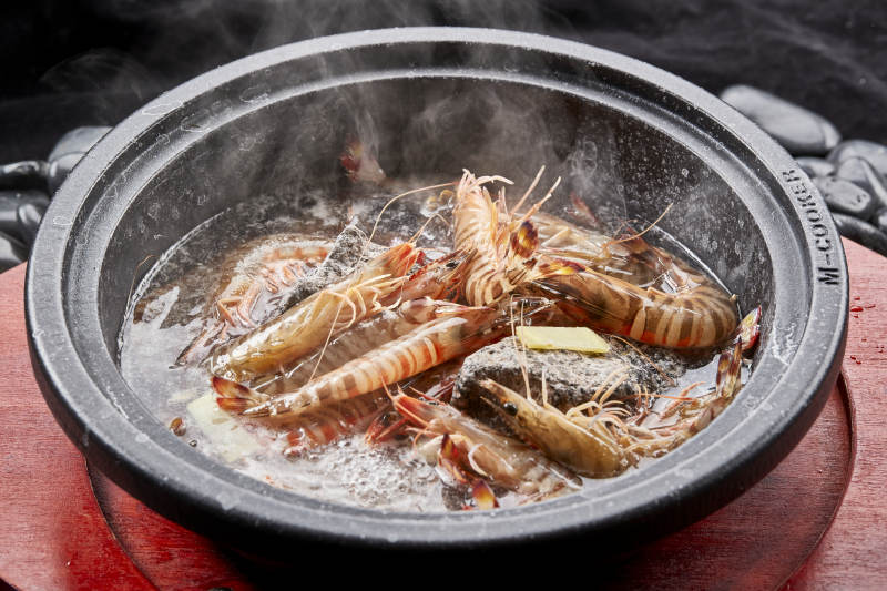 用加热的火山岩石烹煮的新鲜基围虾岩烧