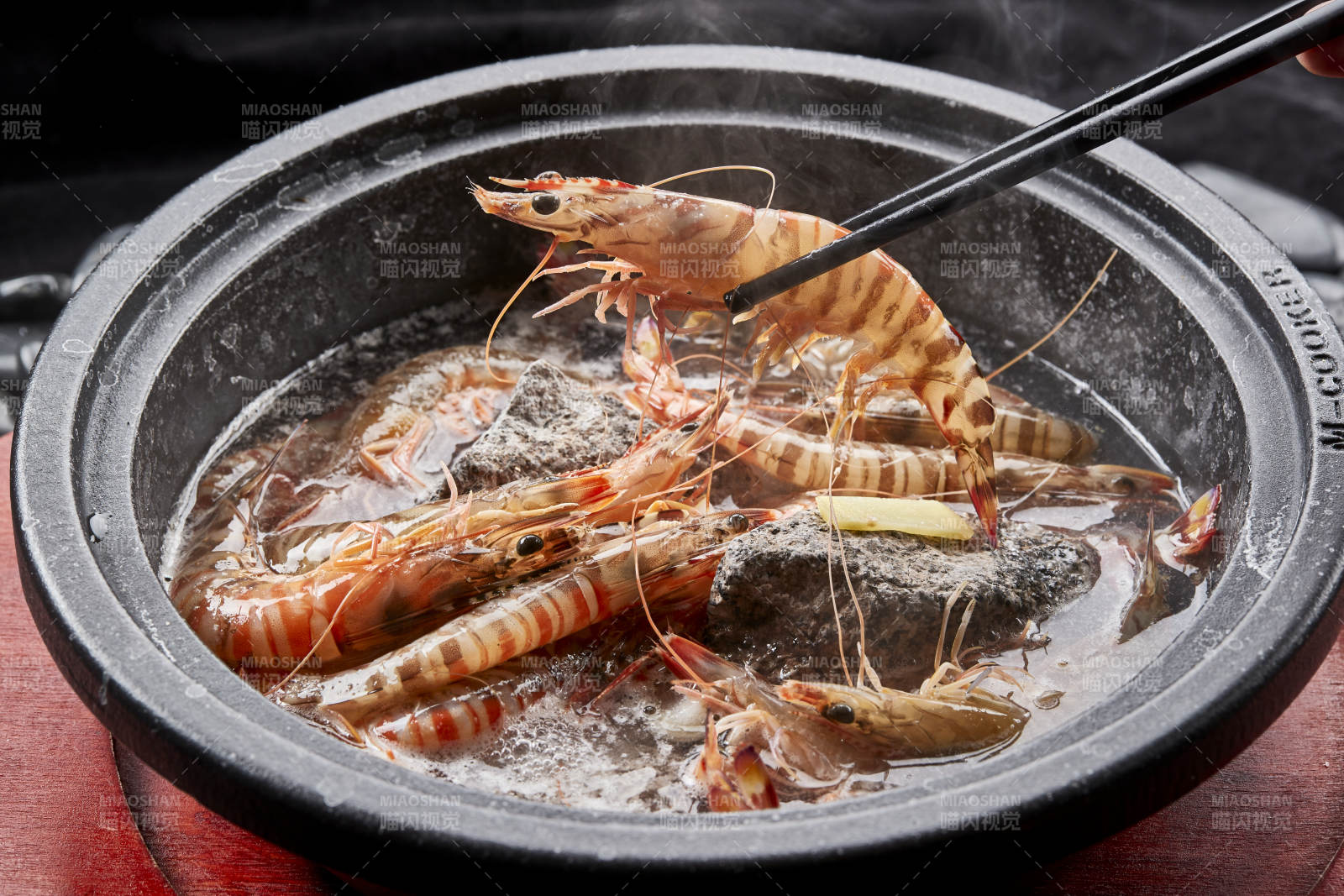 用加热的火山岩石烹煮的新鲜基围虾岩烧