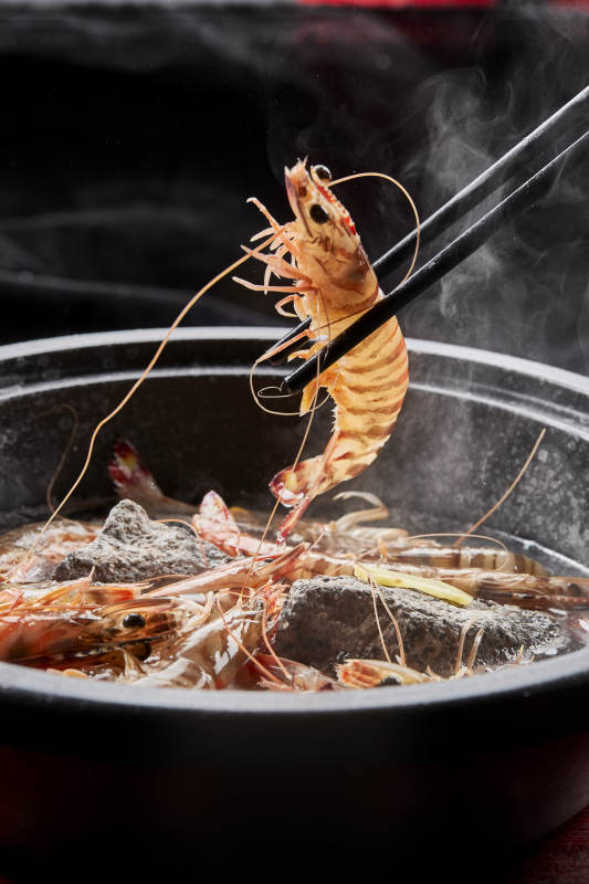 用加热的火山岩石烹煮的新鲜基围虾岩烧