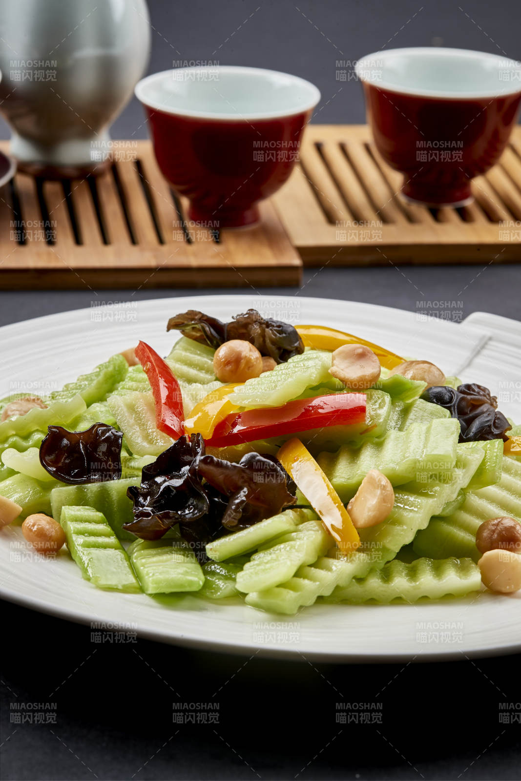 圆瓷盘装的彩椒木耳乳瓜炒银杏-摄影图