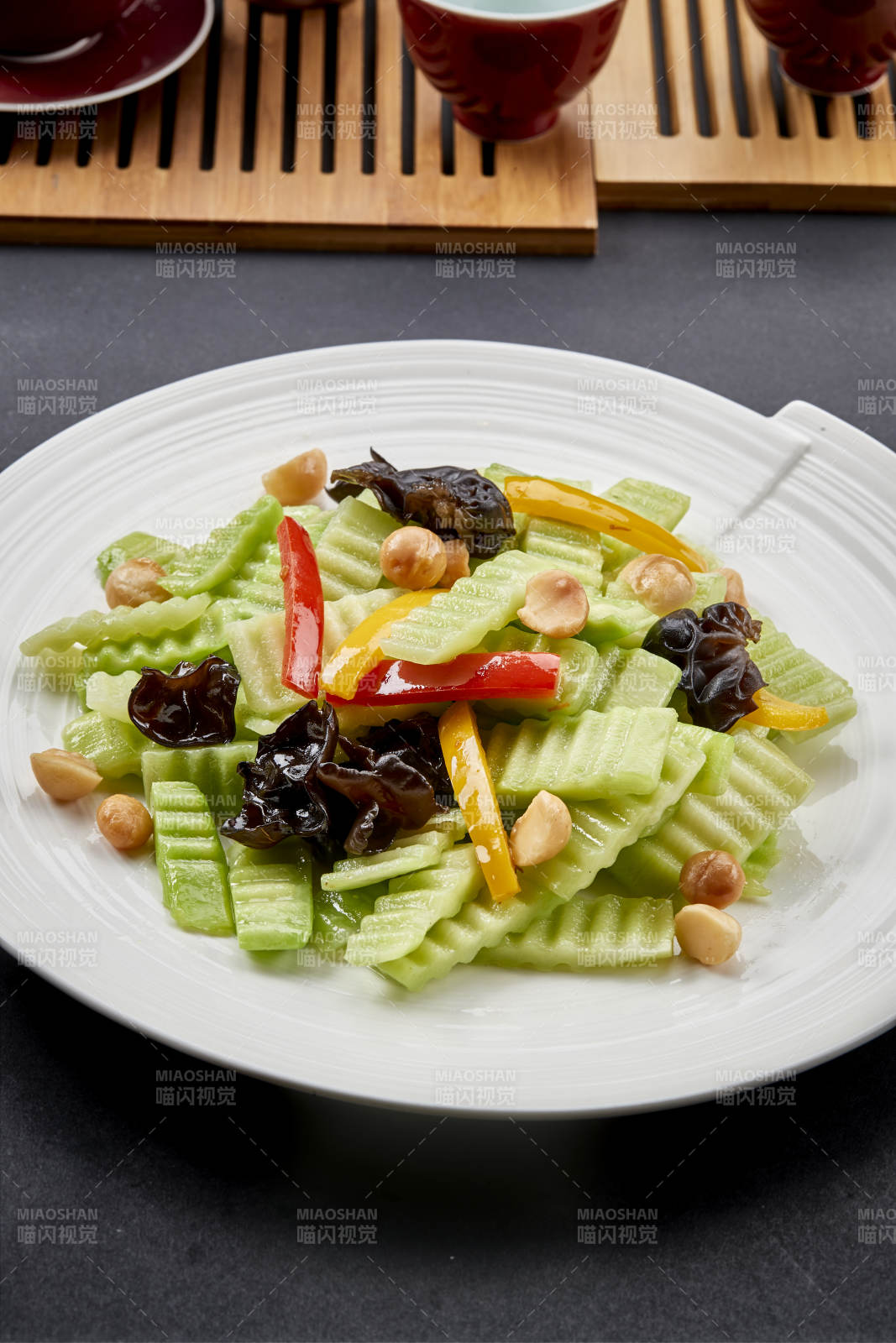 圆瓷盘装的彩椒木耳乳瓜炒银杏-摄影图