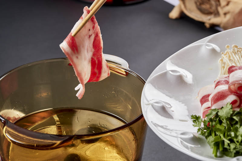 向岩石加热的沸腾食用油中投放鲜美肥牛片