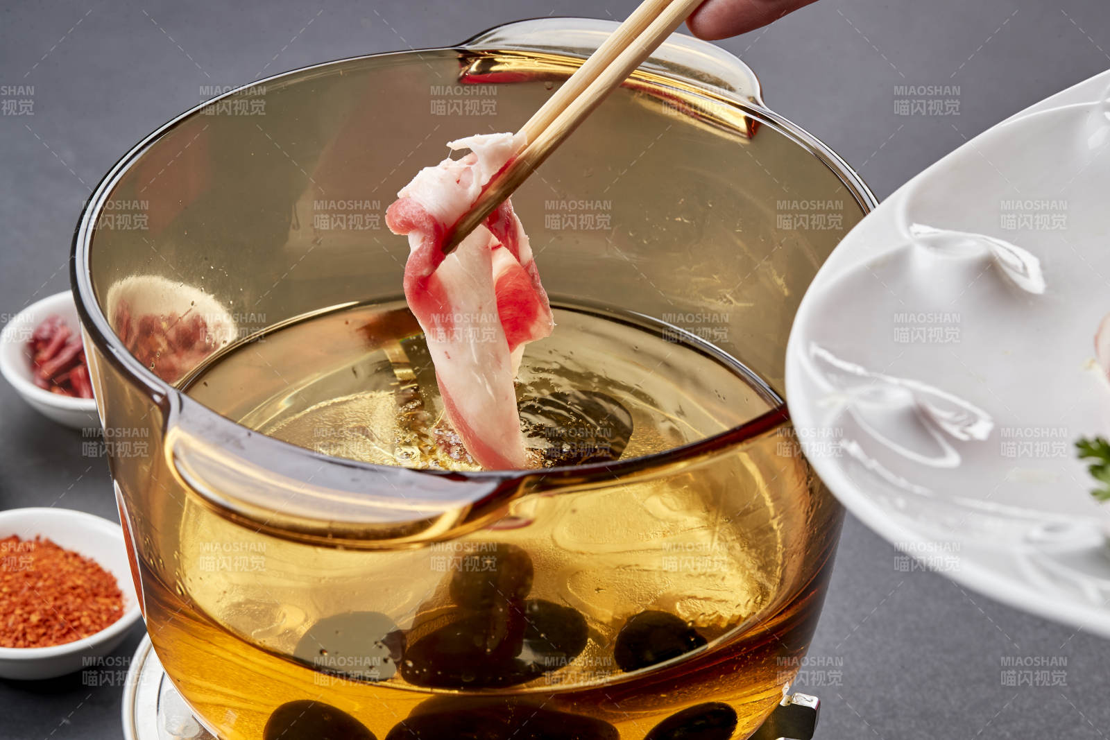 向巖石加熱的沸騰食用油中投放鮮美肥牛片