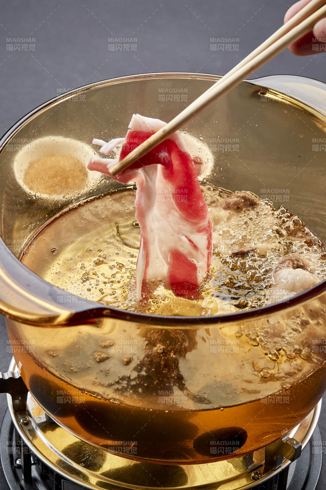 向巖石加熱的沸騰食用油中投放鮮美肥牛片
