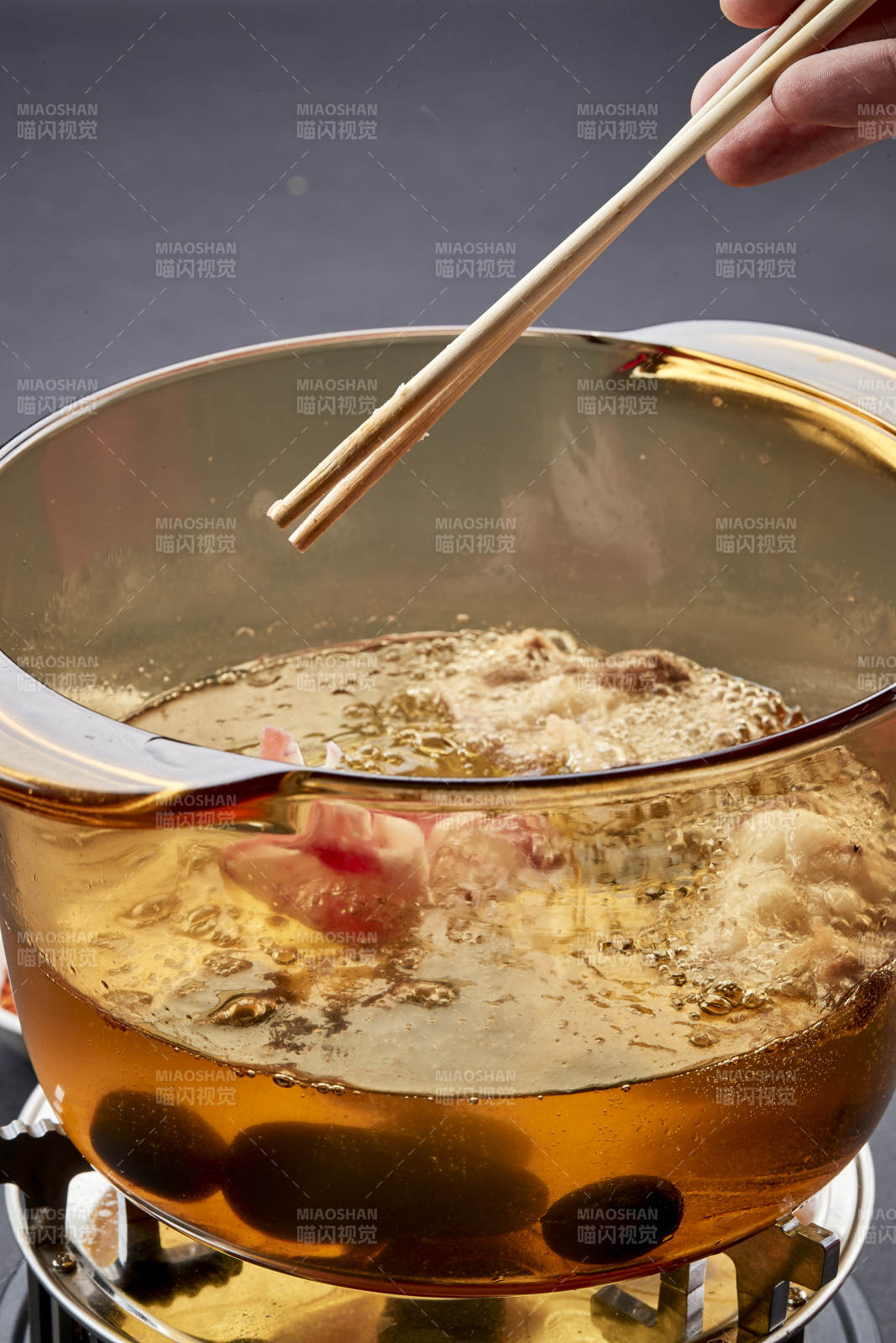 向巖石加熱的沸騰食用油中投放鮮美肥牛片