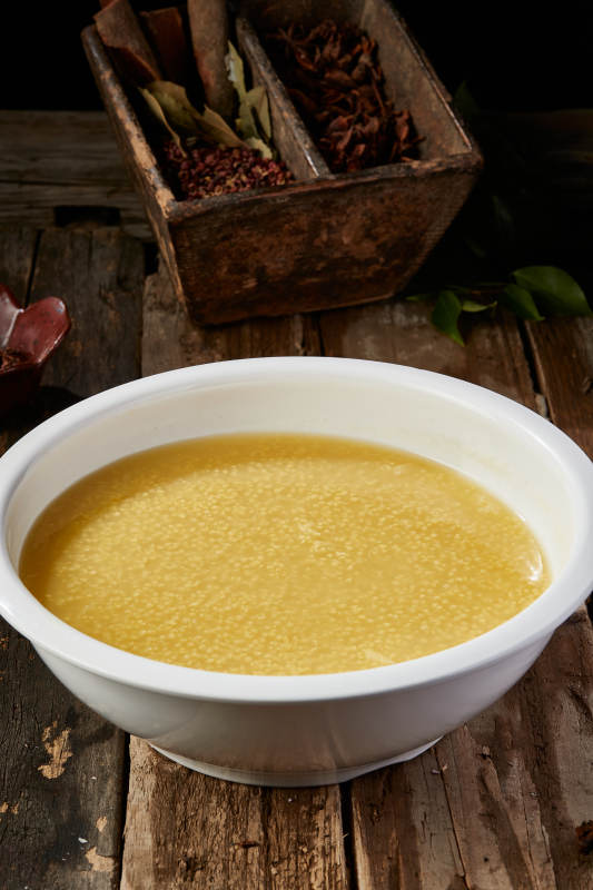 白色瓷盆装的黄金奶汤小米粥