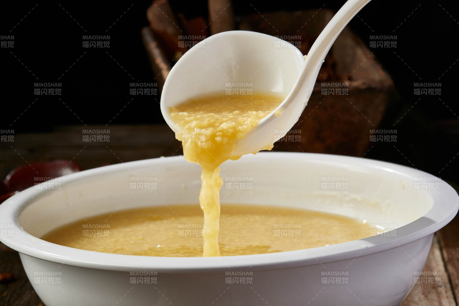 白色瓷盆装的黄金奶汤小米粥