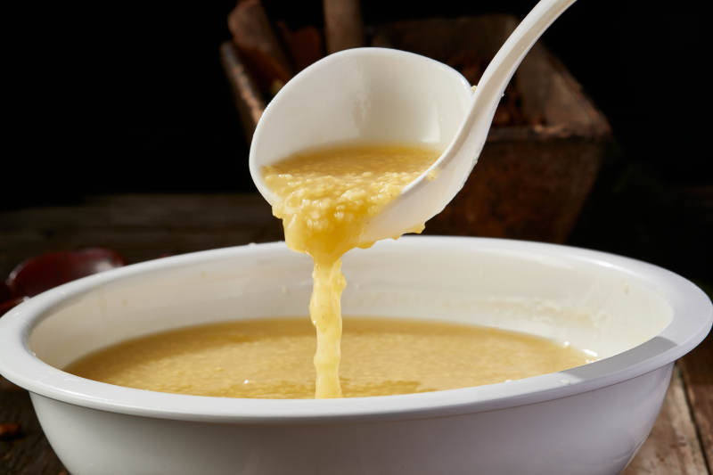 白色瓷盆装的黄金奶汤小米粥