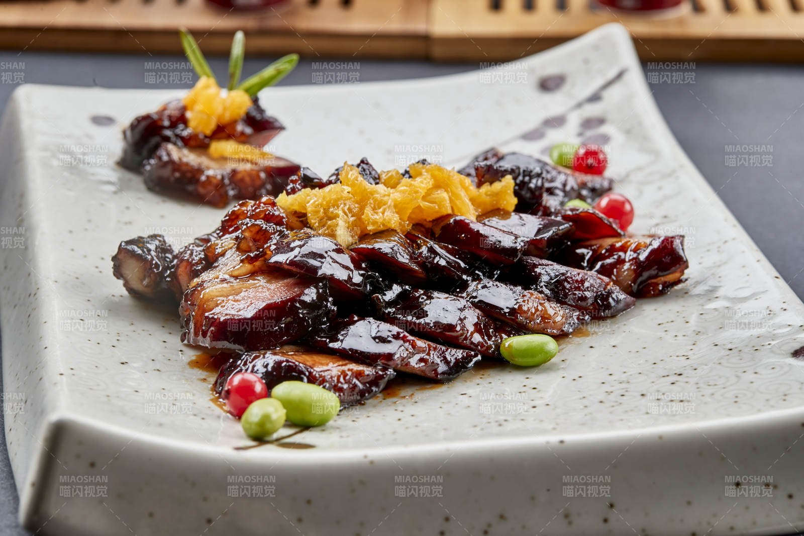 方形瓷盘装的蜜汁烧腊猪里脊肉
