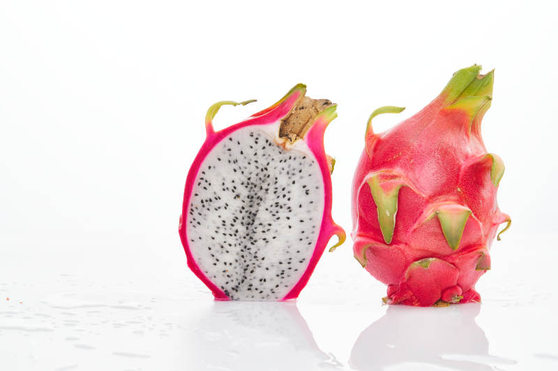 白色背景上摆放切开的新鲜火龙果