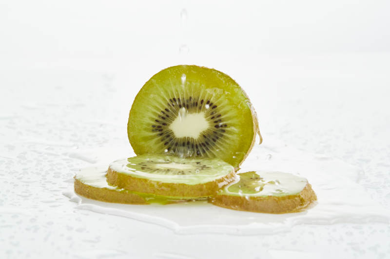 白色背景上摆放的水润猕猴桃切片
