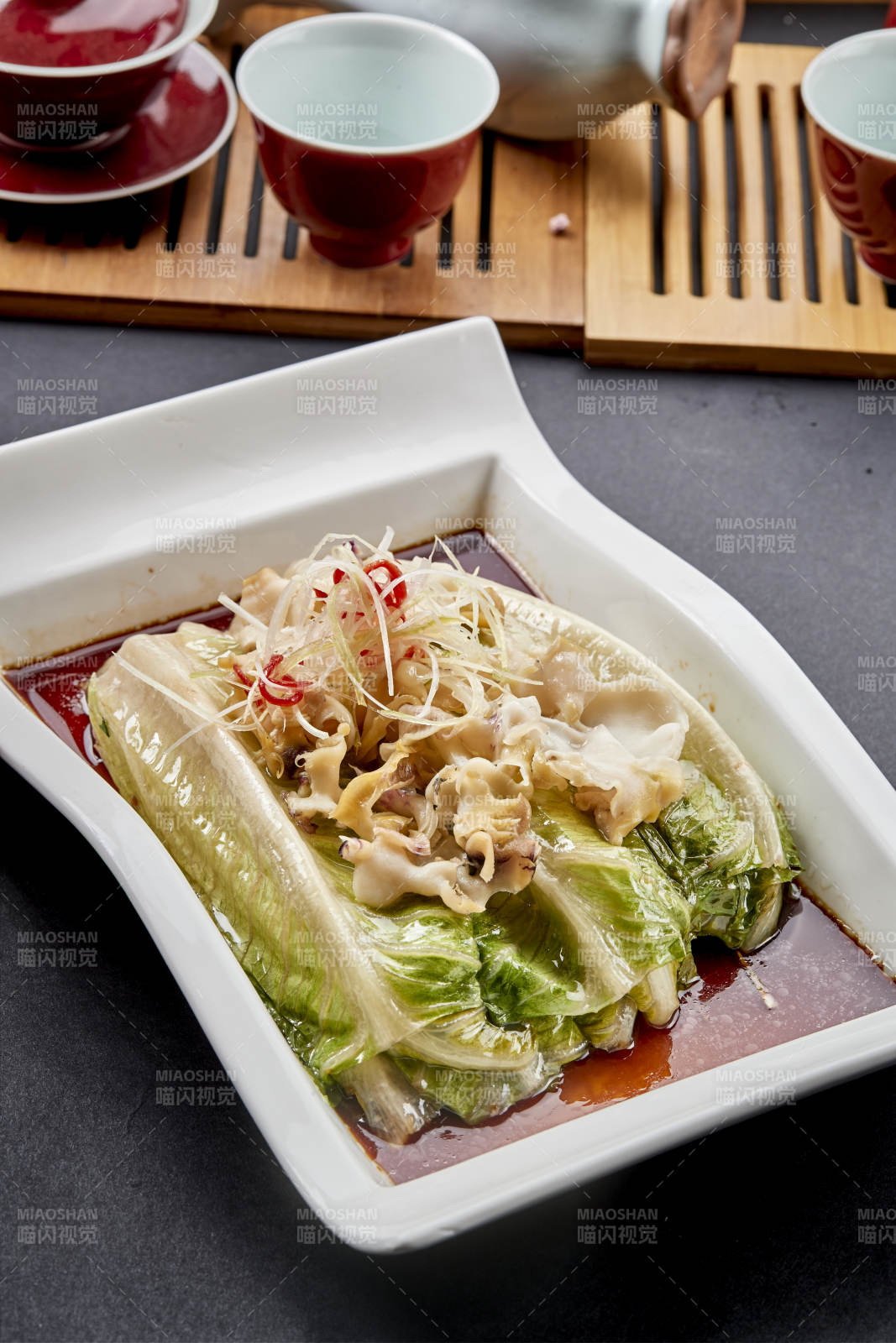 长瓷盘装的清蒸浇汁生菜螺片