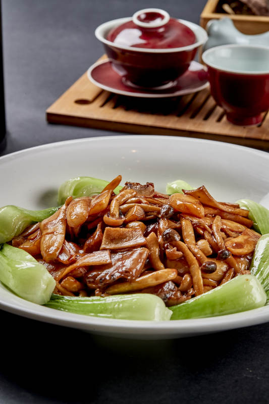 白色瓷盤裝的美味魯菜蔥燒雜菌