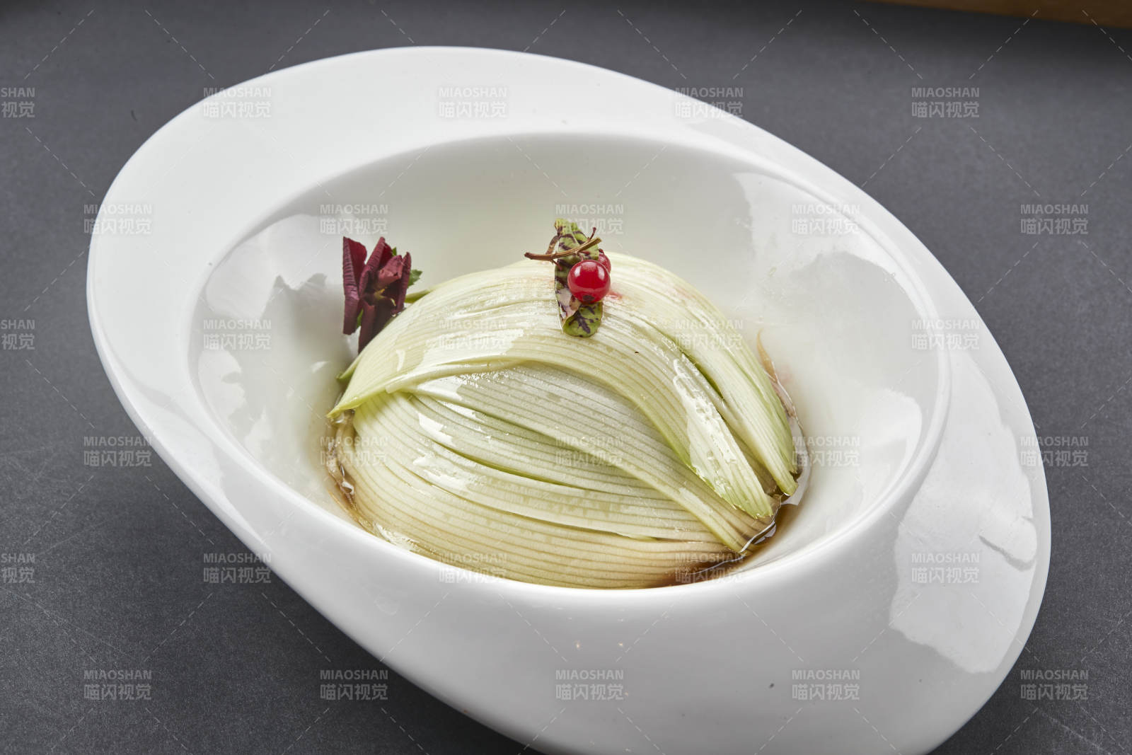 白色椭圆瓷盘装的凉拌浇汁西芹丝