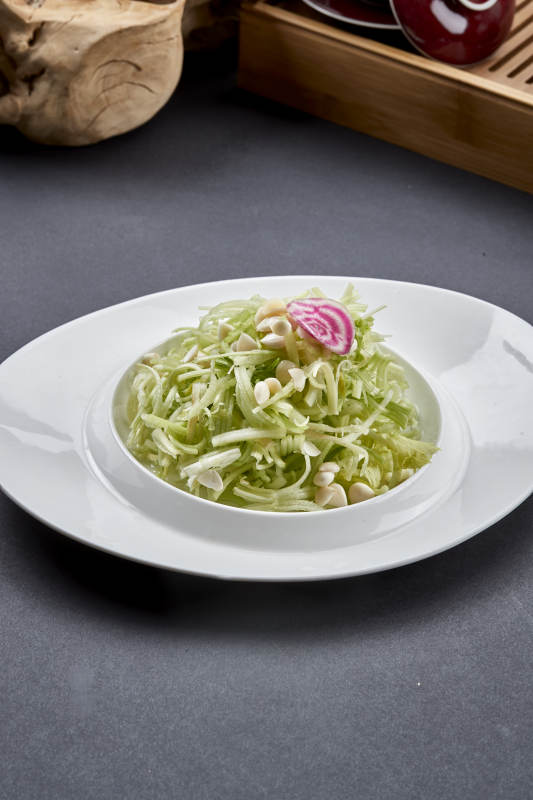 异形白瓷盘装的苦杏仁拌青瓜丝