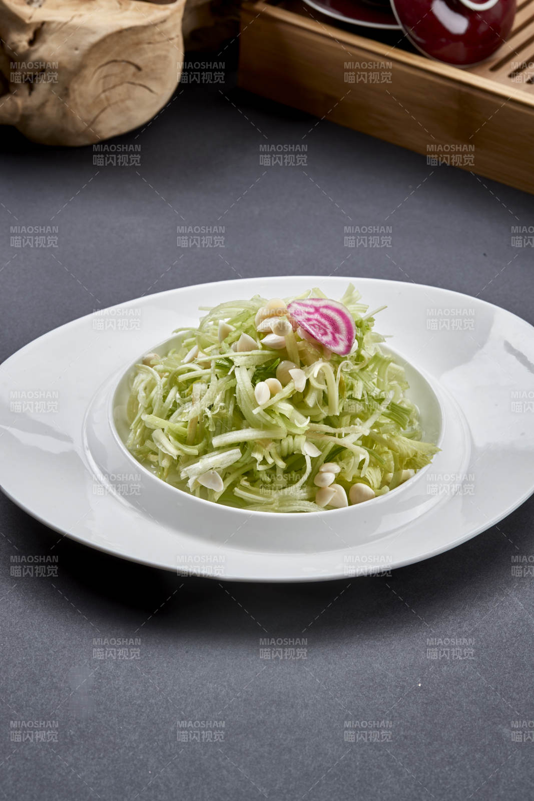 异形白瓷盘装的苦杏仁拌青瓜丝