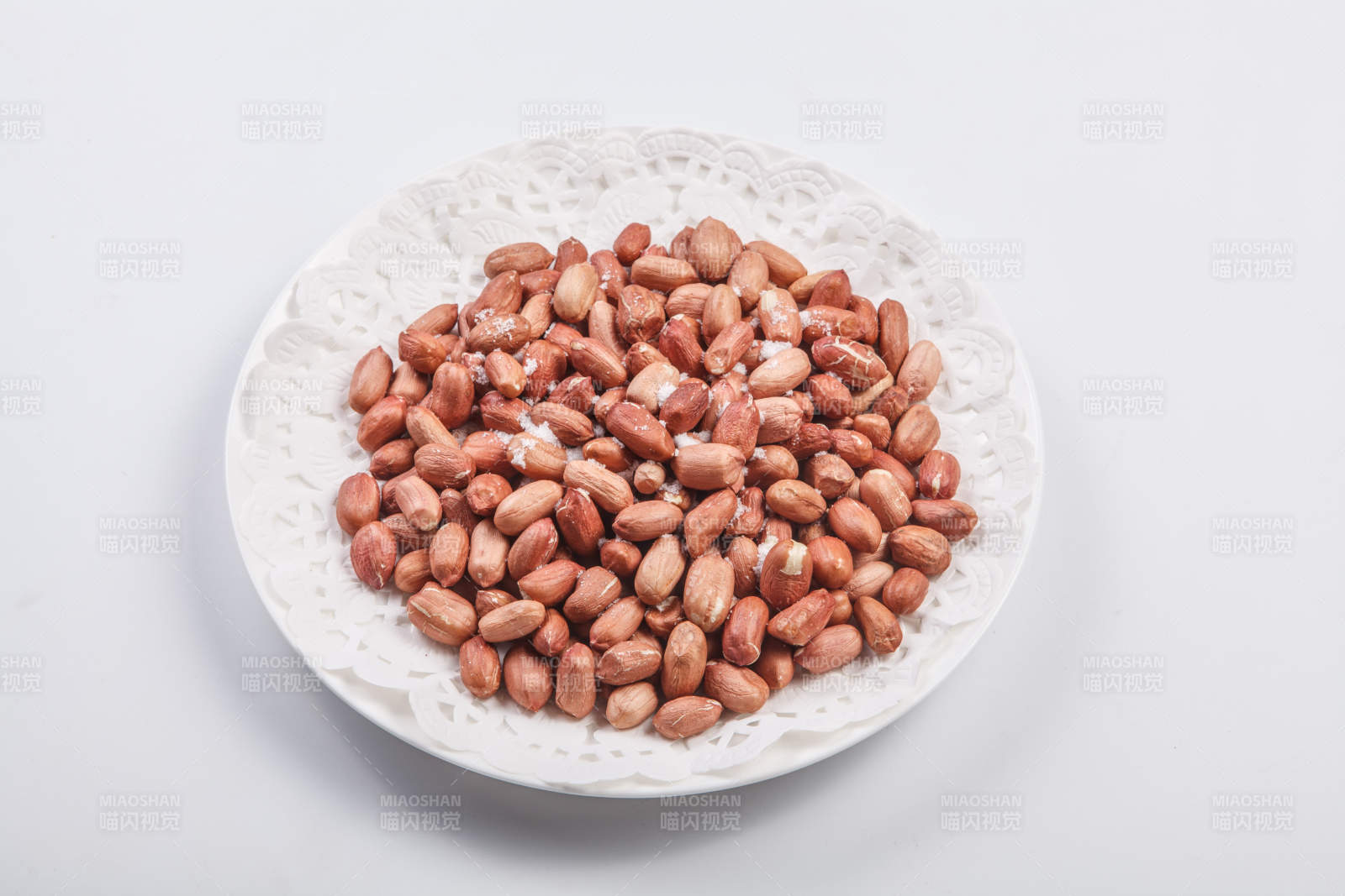 白色瓷盤裝的一碟花生米-攝影圖