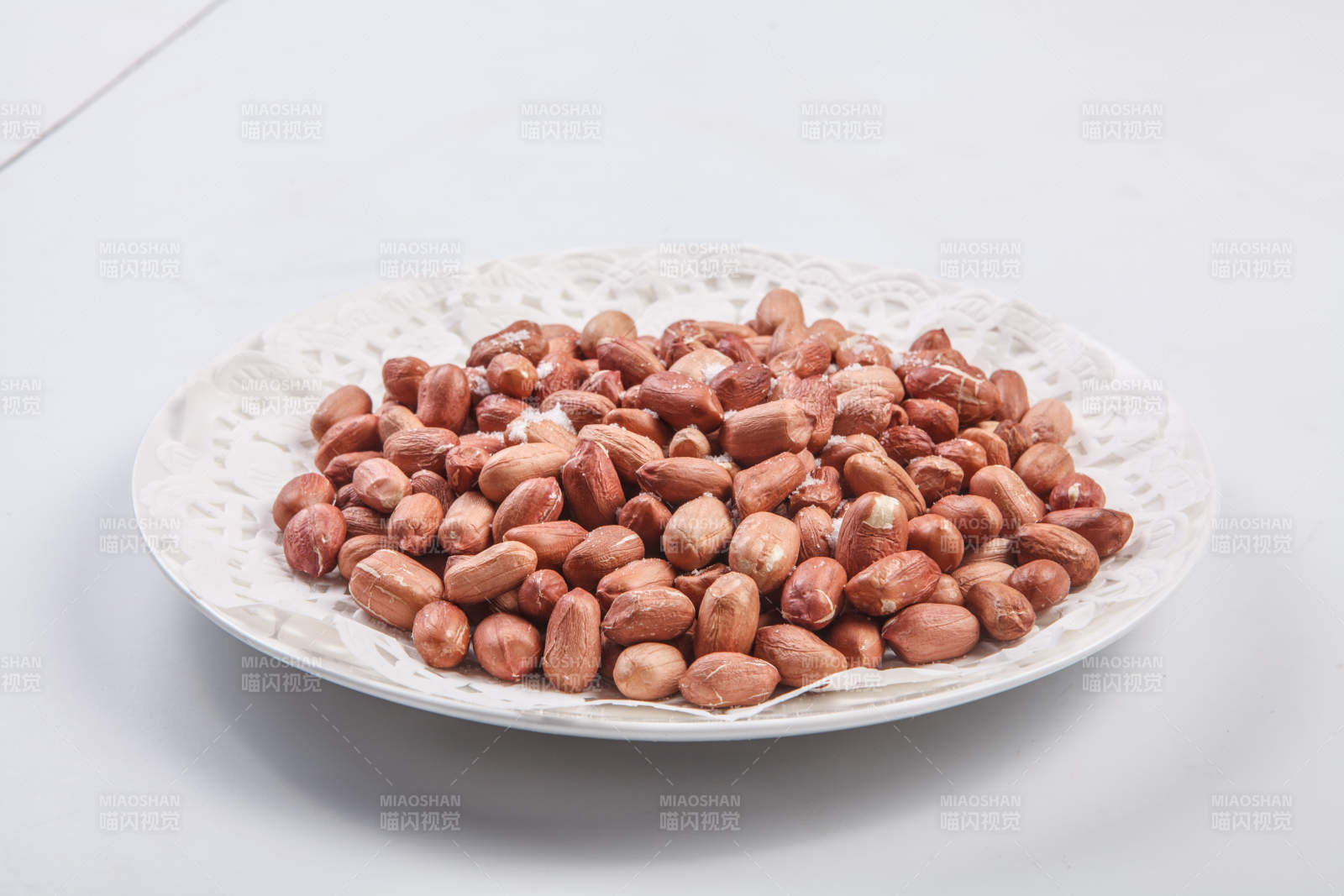 白色瓷盤裝的一碟花生米-攝影圖