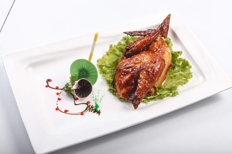 白色瓷盘装的半只脆皮鸡