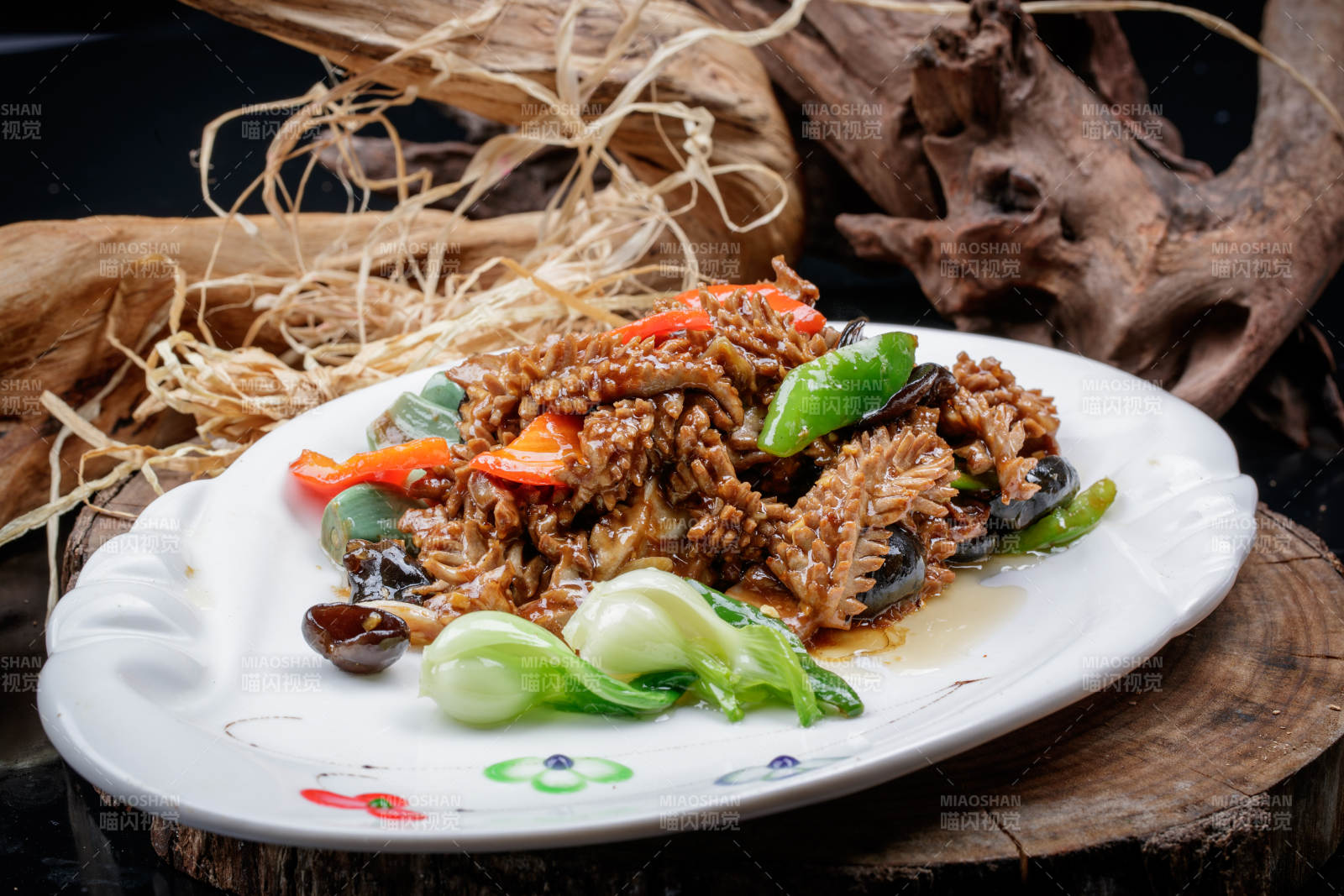 橢圓瓷盤(pán)裝的臘八蒜炒腰花擺放在樟木砧板上