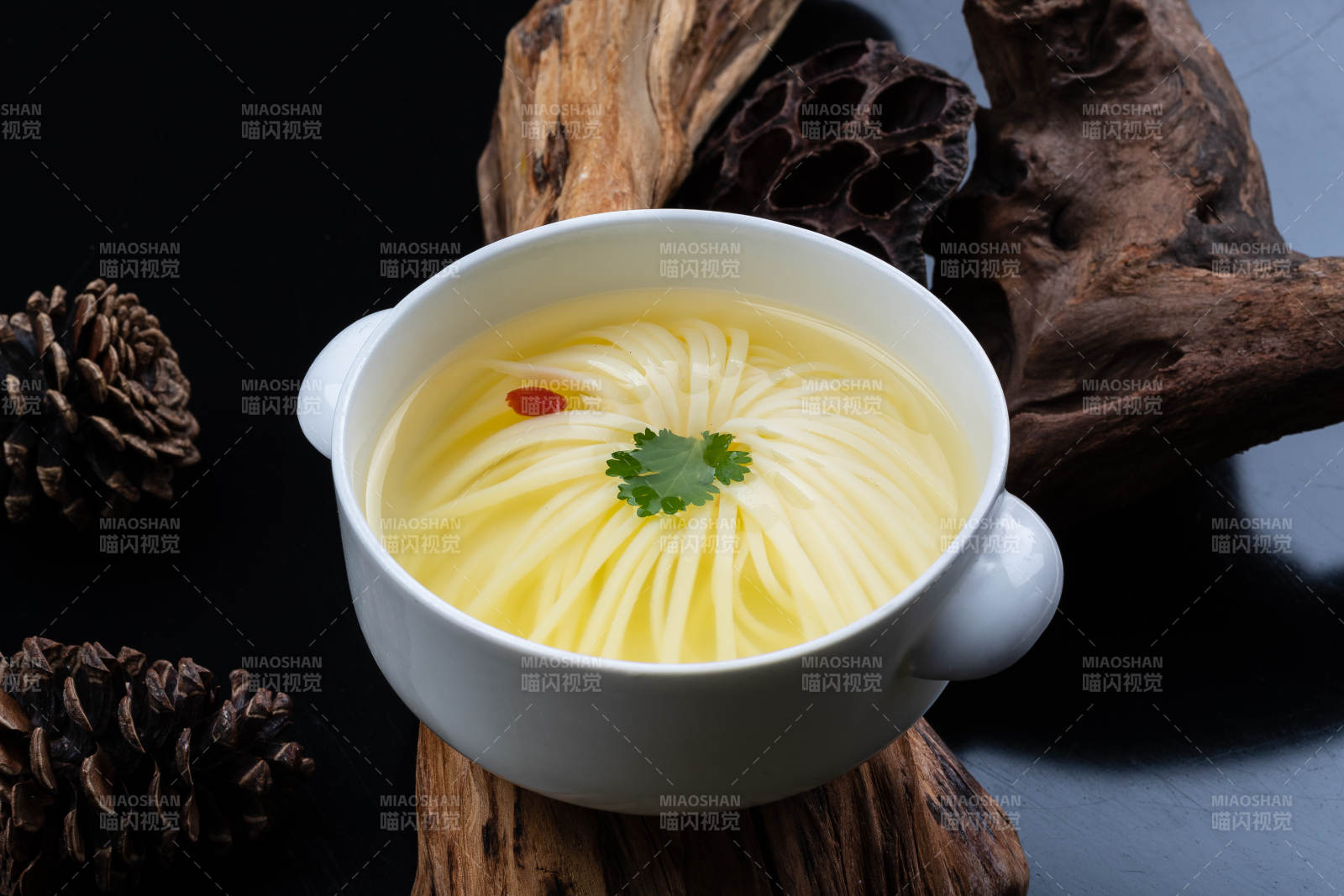 白色湯盅裝的文菊豆腐養(yǎng)生湯擺放在崖柏根上