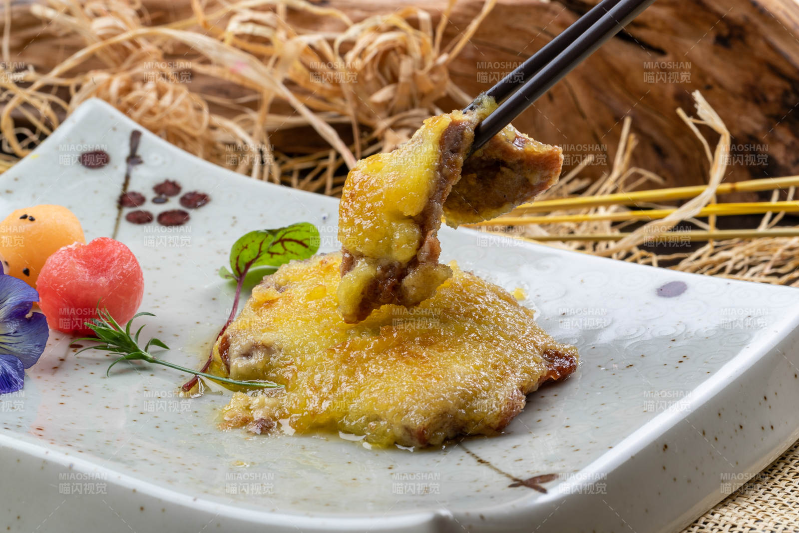 青色瓷盤裝的黃金炸豬排擺放在麻布墊子上