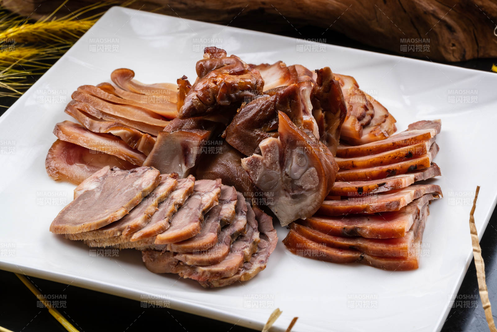 方形瓷盘装的卤肉拼盘摆放在黑色背景上