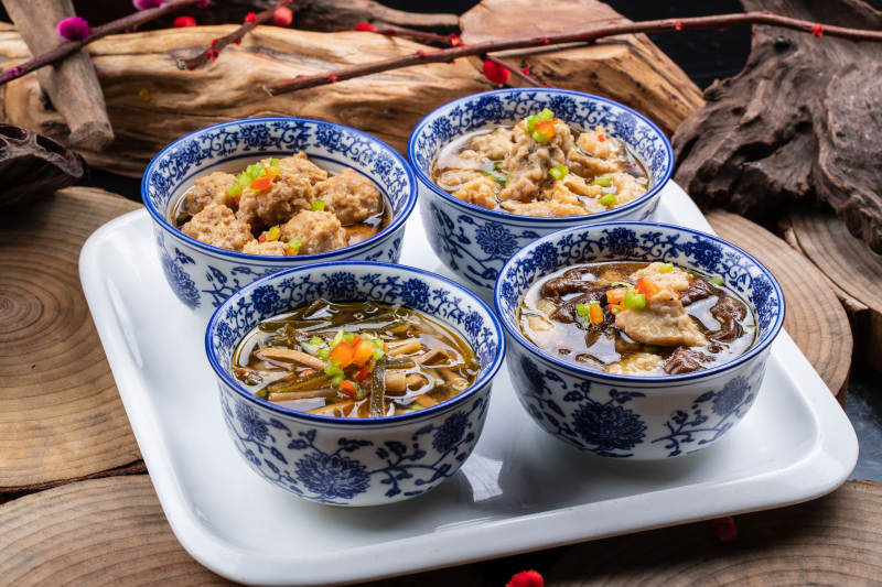 青花瓷碗装的传统四大碗摆放在樟木砧板上