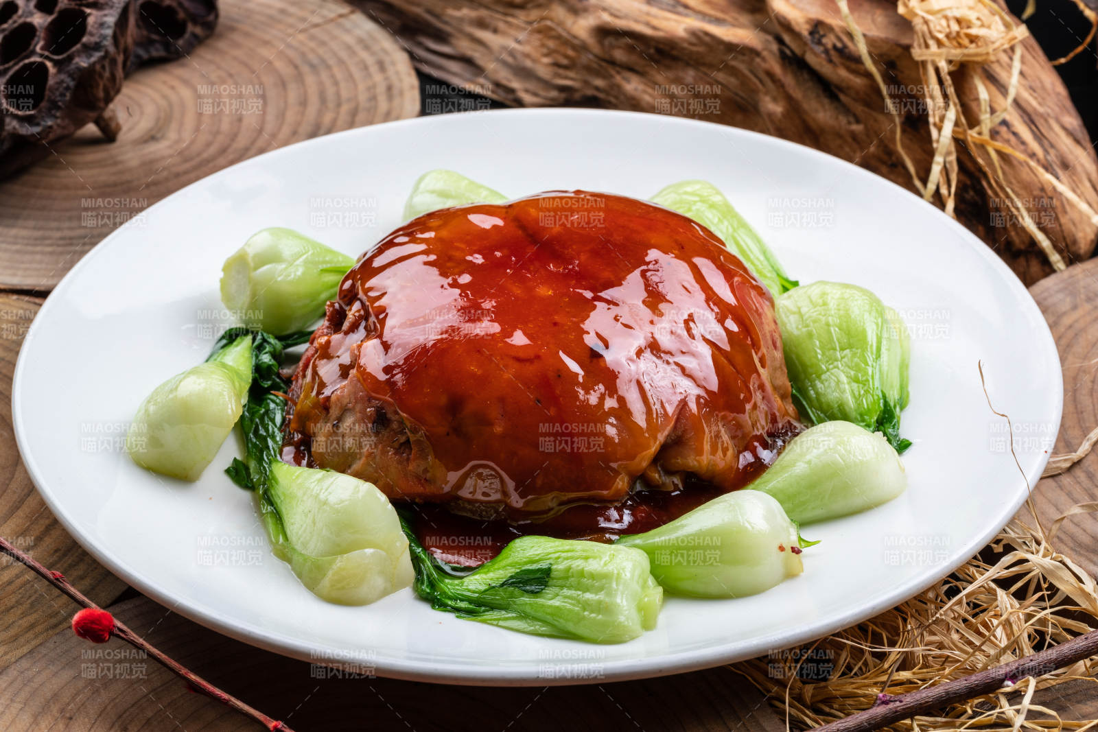 圆形瓷盘装的红焖扣肉摆放在樟木砧板上