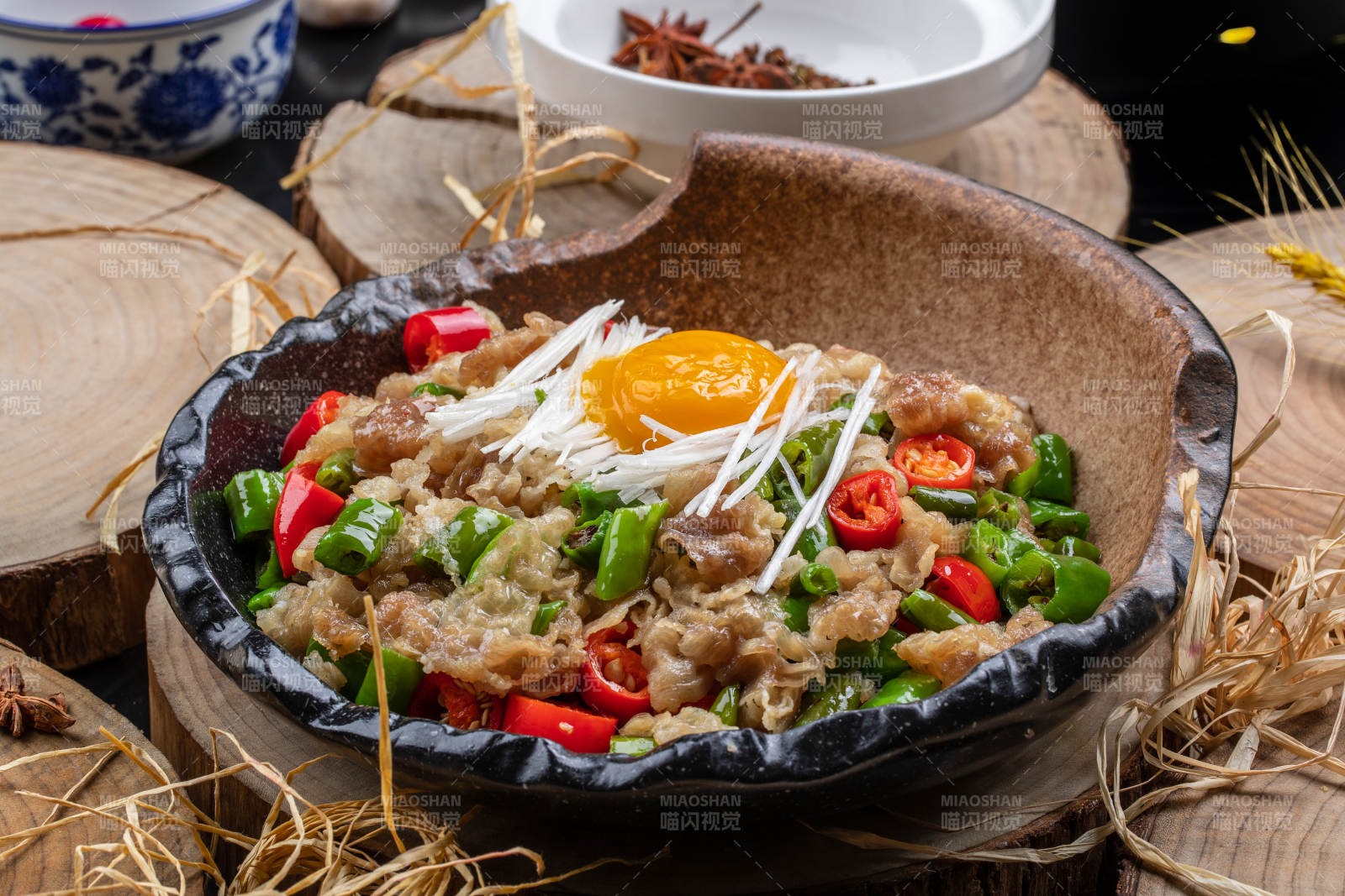 陶盘装的小米辣炒肥牛摆放在樟木砧板上