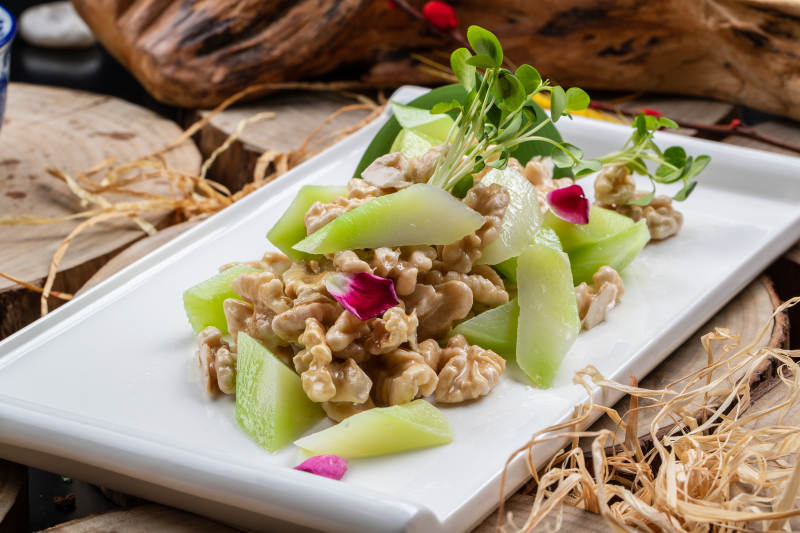 白瓷盘装的西芹鲜桃仁