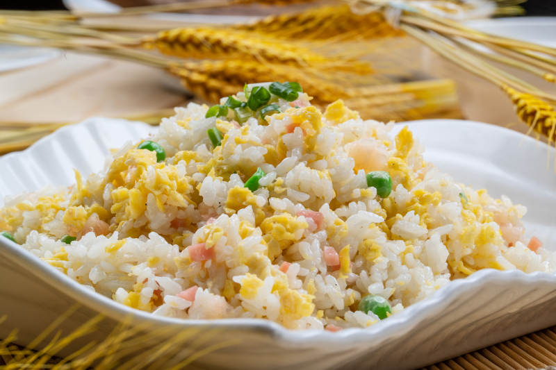 白瓷盘装的火腿虾仁青豆蛋炒饭