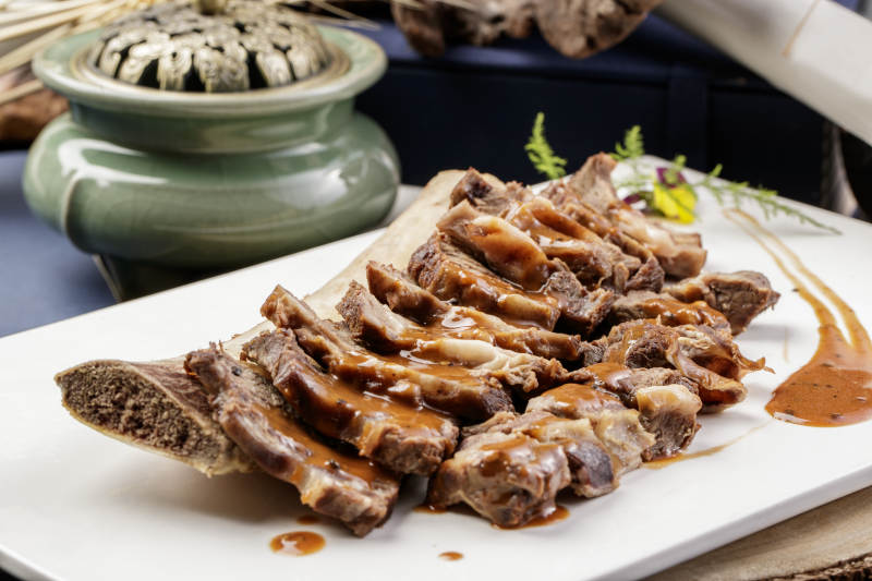 黑胡椒酱汁牛肋剔骨肉摆放在樟木砧板上