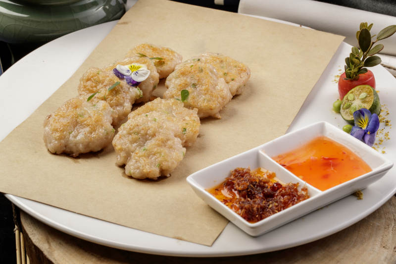 白色瓷盘装的的油炸虾肉饼