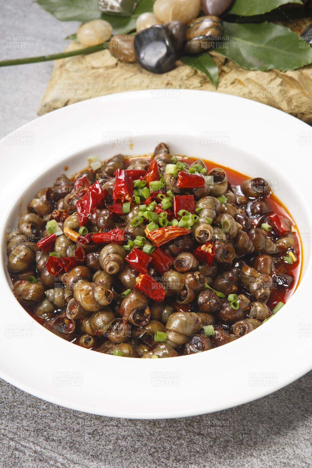 白色瓷盤裝的香辣炒田螺