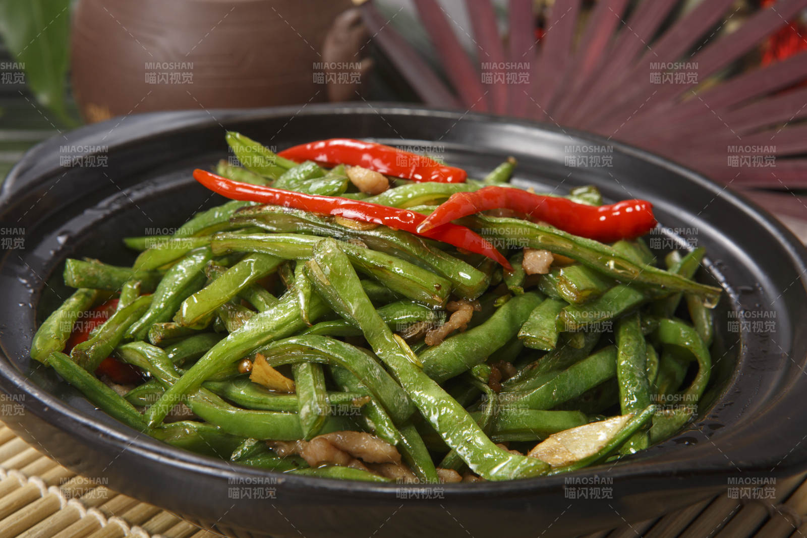 黑色砂锅装的米椒肉丝煲豇豆丝