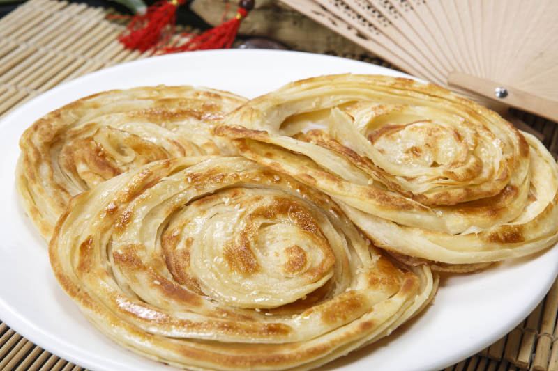 白色圆盘装的葱油饼