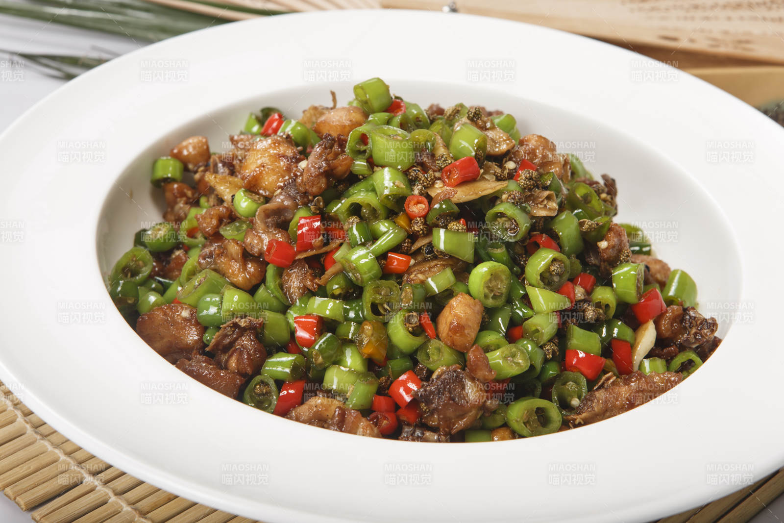 白色瓷盤(pán)裝的米椒爆山雞-攝影圖