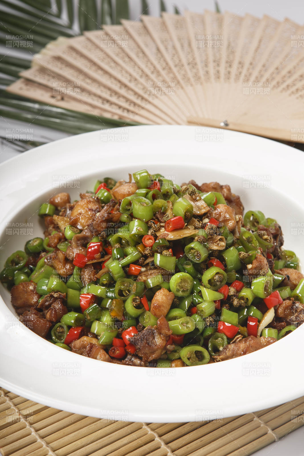 白色瓷盘装的米椒爆山鸡-摄影图