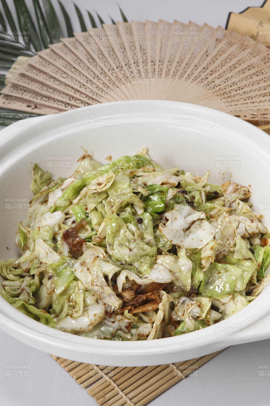 壽司簾上的白色砂鍋裝的油渣爆包菜