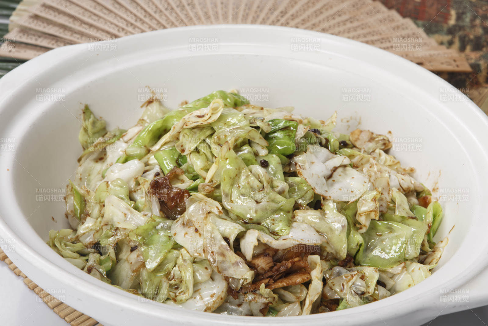 壽司簾上的白色砂鍋裝的油渣爆包菜