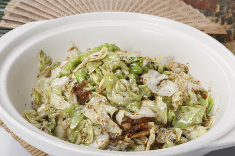 壽司簾上的白色砂鍋裝的油渣爆包菜