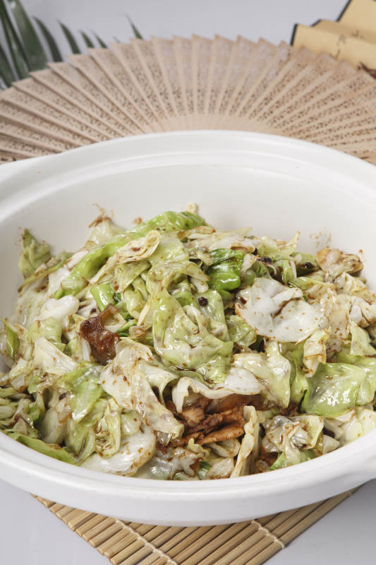 壽司簾上的白色砂鍋裝的油渣爆包菜