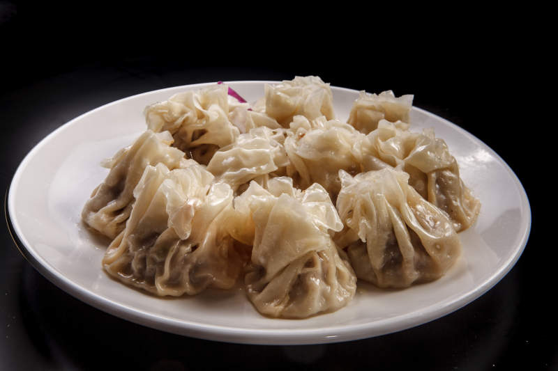 白色瓷盘装的都一处烧麦