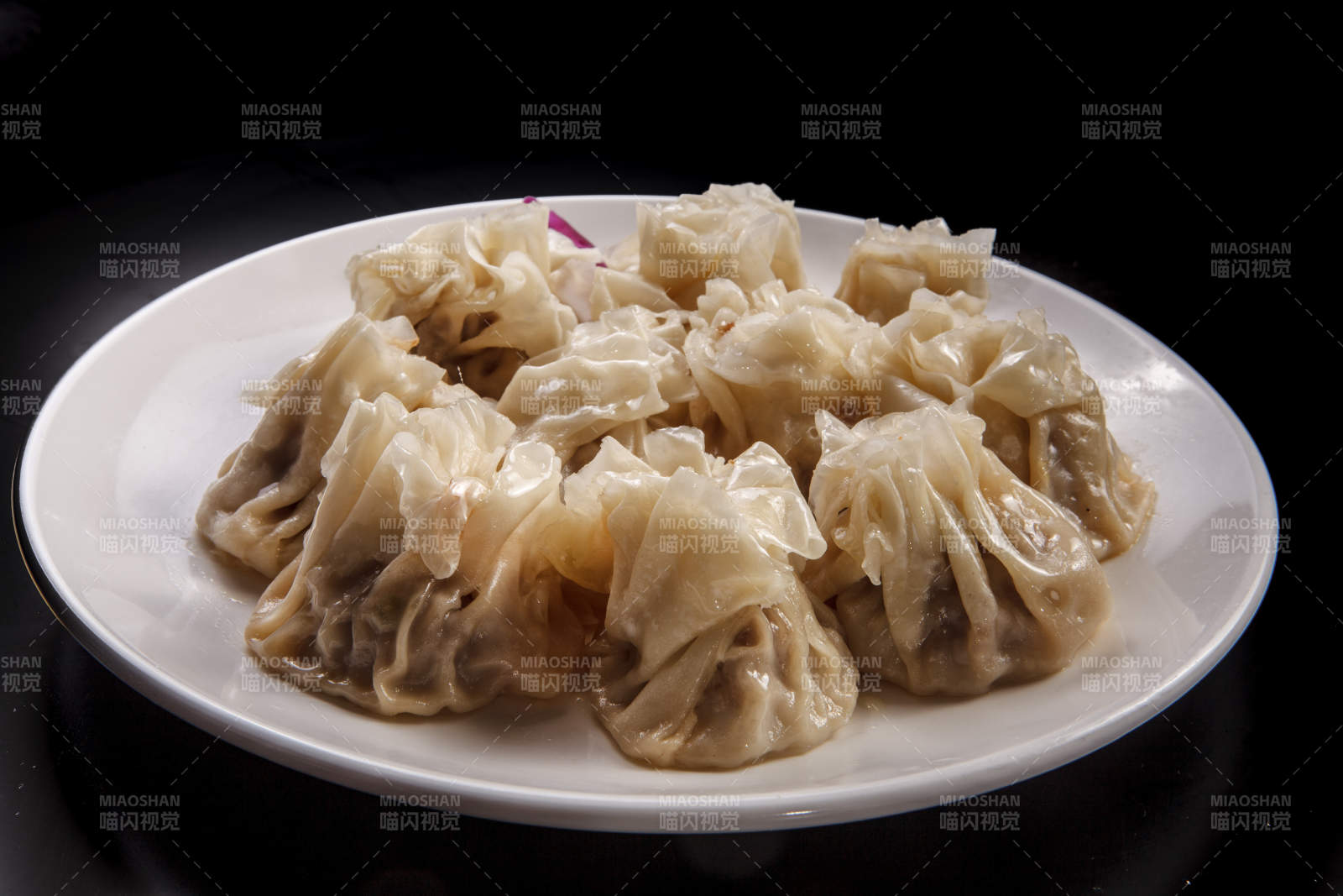 白色瓷盘装的都一处烧麦